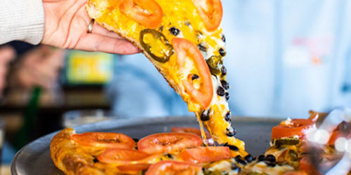 Hand Picking Up Slice of Jalapeno and Tomato Pizza
